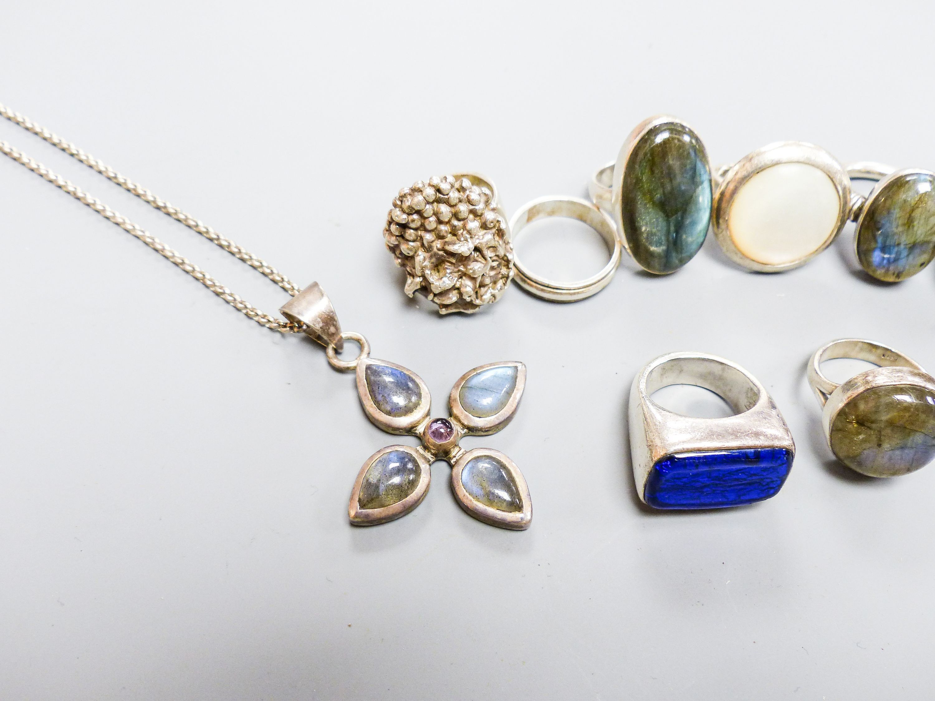 Six assorted white metal and gem set dress rings, a white metal band and dress ring and a white metal pendant on chain.